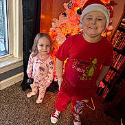 Jude is registered to the contest to win money with this photo: child, children, christmas_tree, holiday, festive, santa_hat, pajamas, toy, carpet, window, bookshelf, dvd, smiling, indoors, decorations, ornaments, red_clothing, white_tree, happy, family