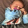 baby, sleeping, pacifier, blanket, bed, blue_clothing, infant, peaceful, cute, child, resting, soft, indoors, cozy, hands, face, head, young, toddler, comfort