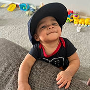 Heath joined the competition — help win amazing prizes! toddler, child, cap, black_tshirt, red_trim, carpet, toys, colorful, wall, electrical_outlet, hand, face, smile, indoor, furniture, playroom, baby, person, expression, cheeky