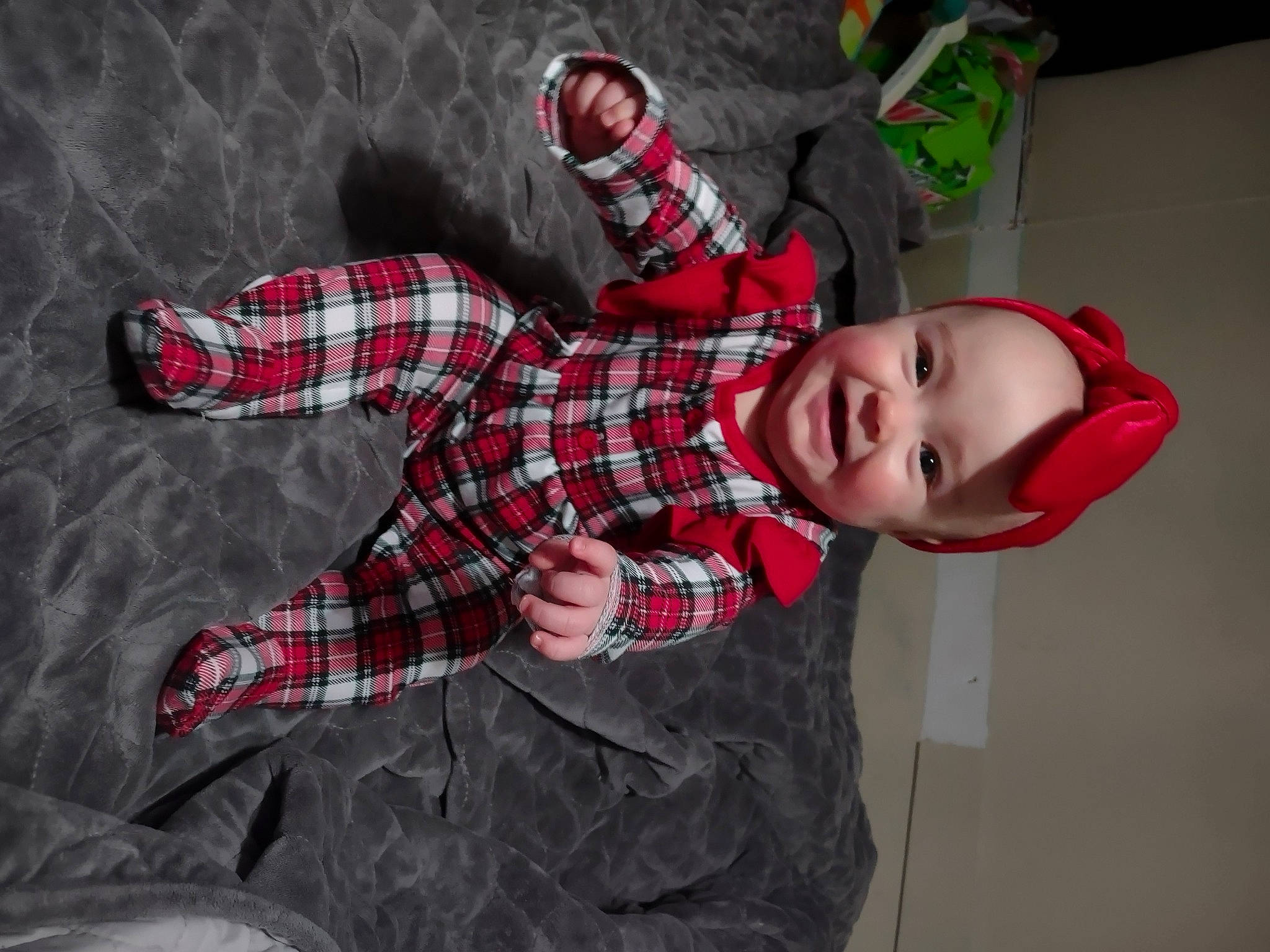 Racheal is registered to the contest to win money with this photo: baby_toddler_clothing, carmine, child, comfort, costume, doll, flooring, fun, happy, headwear, linens, pattern, person, plaid, room, sleeve, smile, stuffed_toy, tartan, textile