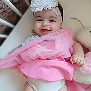 Melina participe au concours pour gagner de l'argent avec cette photo : baby, smiling, headband, flower, pink, fabric, soft_toy, plush, cute, happy, infant, child, portrait, lying_down, hand, clothing, indoors, face, closeup, toddler