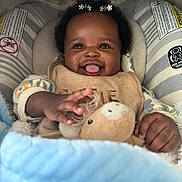 Dahlia joined the competition — help win amazing prizes! baby, blanket, child, clothing, comfort, cozy, cushion, cute, expression, hair_accessory, hand, happy, indoor, infant, person, plush_toy, portrait, seat, smiling, tongue_out