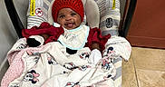 Dahlia joined the competition — help win amazing prizes! baby, bib, blanket, car_seat, child, clothing, cozy, cute, floor, happy, indoor, infant, knit_hat, minnie_mouse, person, red_hat, seat, smile, striped, tile_floor