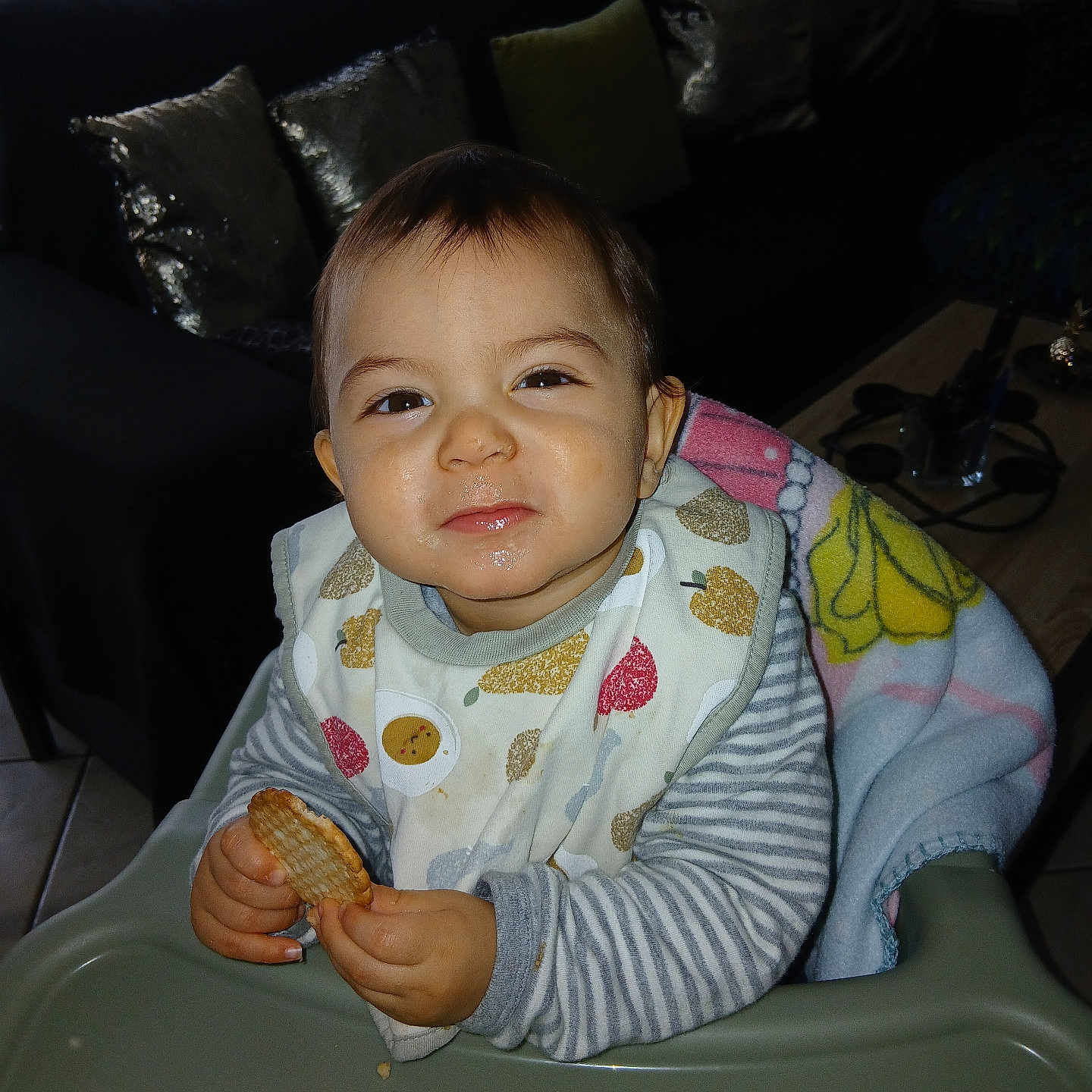 Nahîr participe au concours pour gagner de l'argent avec cette photo : bib, biscuit, blanket, child, clothing, cozy, cute, face, food, high_chair, indoor, living_room, messy_face, person, pillow, smile, sofa, striped_sleeves, table, toddler