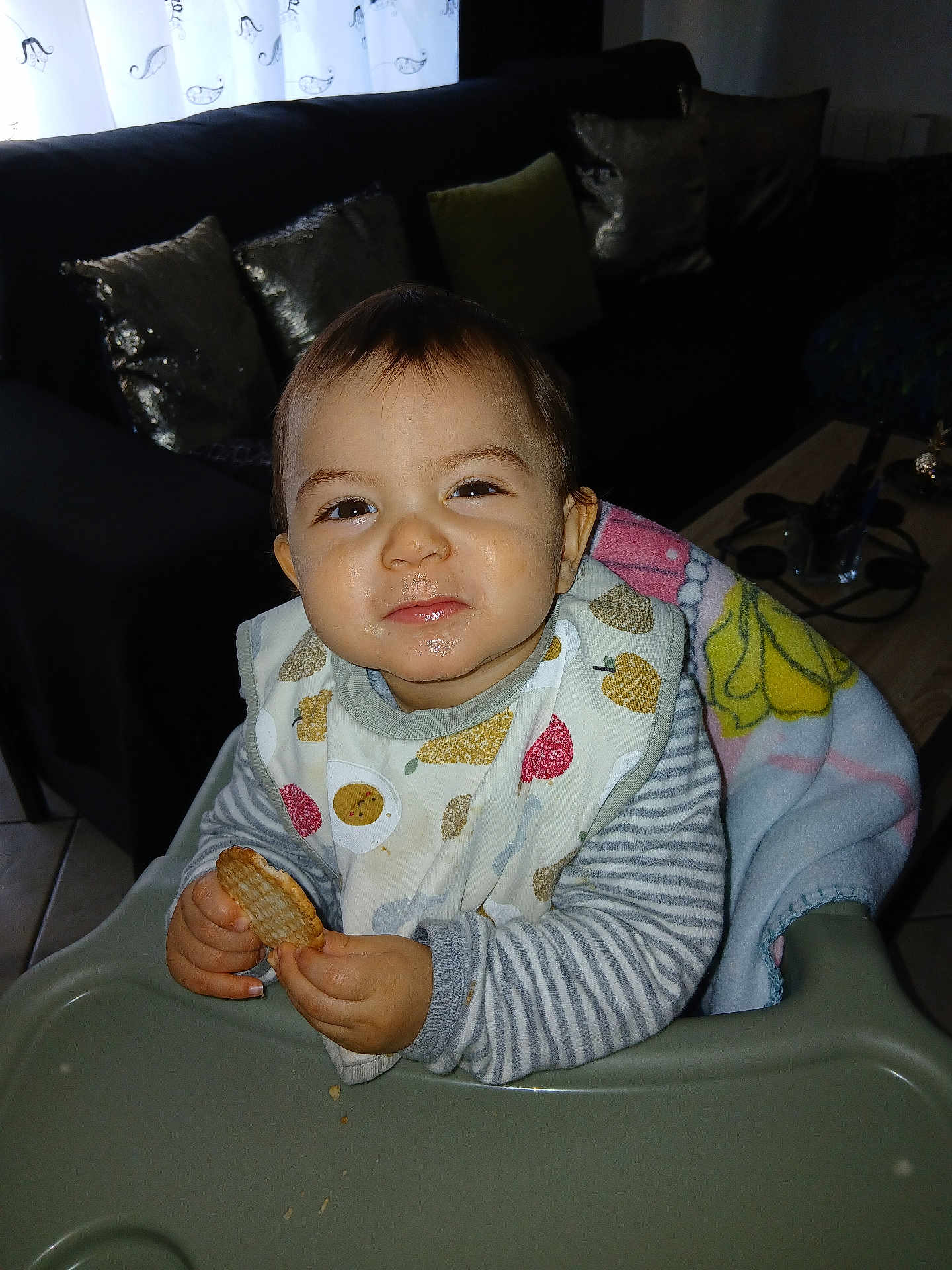 Nahîr participe au concours pour gagner de l'argent avec cette photo : toddler, child, high_chair, biscuit, food, bib, blanket, smile, face, indoor, living_room, pillow, sofa, table, person, clothing, cute, messy_face, striped_sleeves, cozy