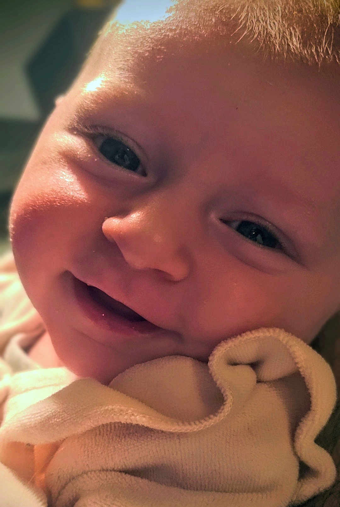 Rose participe au concours pour gagner de l'argent avec cette photo : baby, close_up, face, smile, eyes, blanket, infant, skin, cheeks, expression, child, cute, portrait, young, soft, warm_lighting, newborn, happy, person, indoors