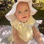 Calah is registered to the contest to win money with this photo: baby, child, outdoor, sunhat, yellow_dress, blanket, grass, smiling, face, skin, sunlight, nature, person, sitting, cute, summer, young, happy, playful, portrait