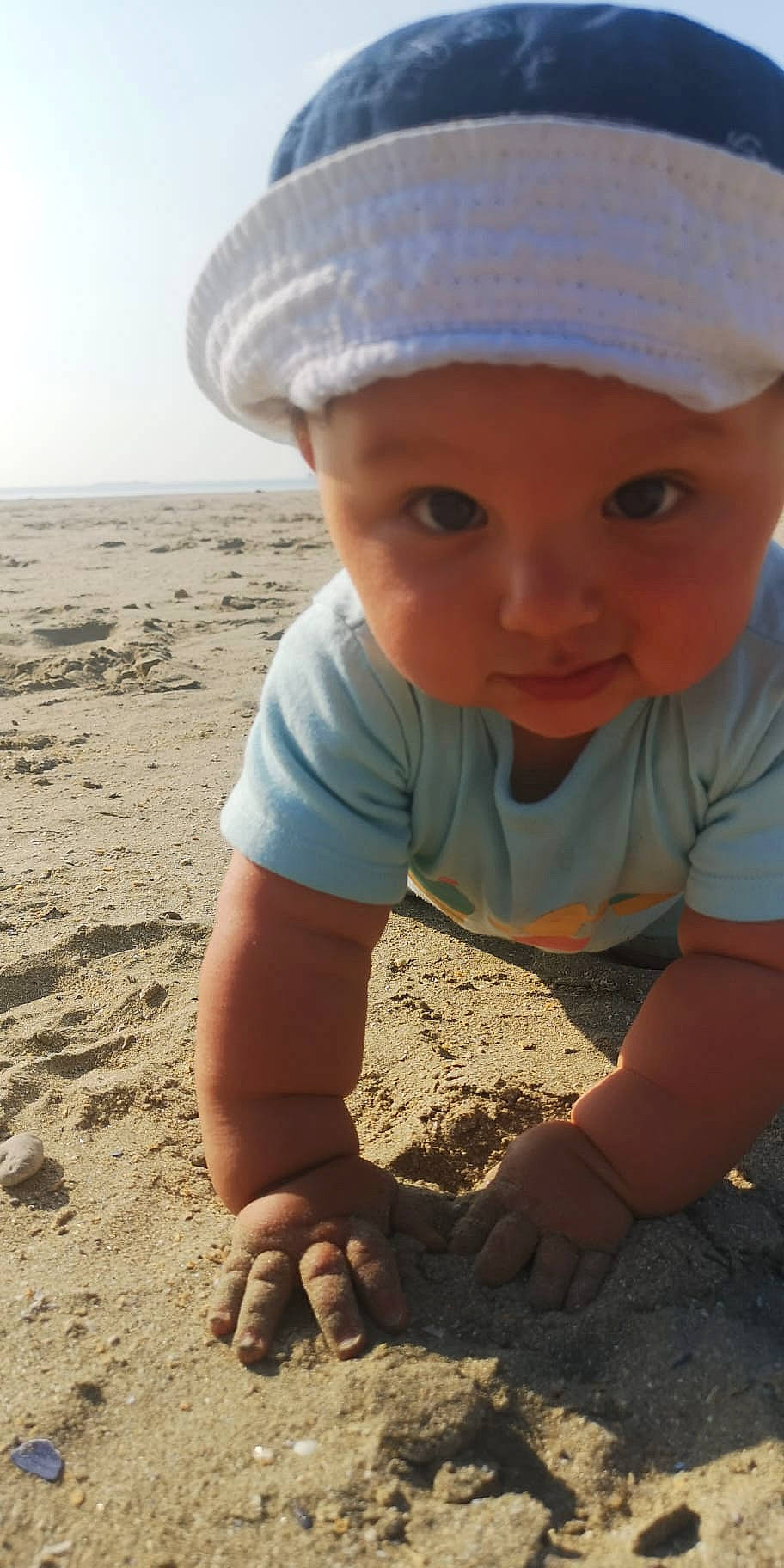 Ismaël a rejoint le concours — aidez-le/la à gagner de superbes lots ! arm, beach, cap, child, clothing, eye, facial_expression, finger, fun, grass, happy, hat, headwear, landscape, people_in_nature, person, photograph, sand, sky, soil