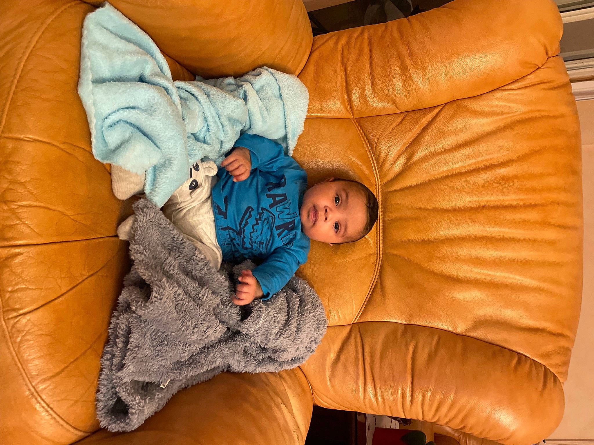 Nahim participe au concours pour gagner de l'argent avec cette photo : baby, baby_toddler_clothing, bedtime, child, comfort, couch, eye, finger, flooring, head, human_body, linens, orange, person, product, sitting, skin, textile, thumb, toddler
