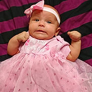 Justinalynn is registered to the contest to win money with this photo: adorable, baby, blanket, bow, child, clothing, cute, expression, fabric, fist, headband, indoors, infant, laying_down, newborn, person, pink_dress, portrait, small, striped_blanket