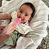 Reyna joined the competition — help win amazing prizes! baby, blanket, bottle, carpet, child, clothing, cushion, drinking, face, feeding, feet, hand, indoor, infant, person, portrait, smile, striped, toddler, young_child