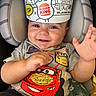 baby, child, smiling, car_seat, tshirt, burger_king_crown, hand, toy, bottle, happy, cute, indoor, infant, clothing, seatbelt, portrait, face, expression, colorful, playful