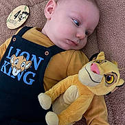 Gabin participe au concours pour gagner de l'argent avec cette photo : baby, baby_outfit, child, clothing, curious, cute, face, indoor, infant, lion_king, lying_down, milestone_marker, plush_toy, portrait, smiling_toy, soft_blanket, stuffed_animal, wooden_milestone, yellow_shirt, young_child