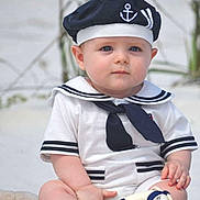 Connor is registered to the contest to win money with this photo: baby, child, sailor_outfit, hat, blue_eyes, toy, life_preserver, sitting, outdoor, cute, portrait, clothing, infant, person, navy_theme, white_clothes, barefoot, summer, young_child, serious_expression