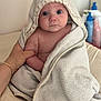 Maëlya a rejoint le concours — aidez-le/la à gagner de superbes lots ! baby, towel, hooded_towel, infant, hand, bracelet, blue_eyes, skin, soft_texture, bath_time, indoor, curious, portrait, person, child, caring_hand, blanket, comfort, newborn, closeup