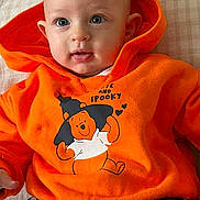 Elio participe au concours pour gagner de l'argent avec cette photo : baby, child, hoodie, orange_clothing, winnie_the_pooh, halloween, bat, cushion, pillow, text, face, eyes, sitting, black_pants, white_stripes, indoor, cute, infant, portrait, smiling