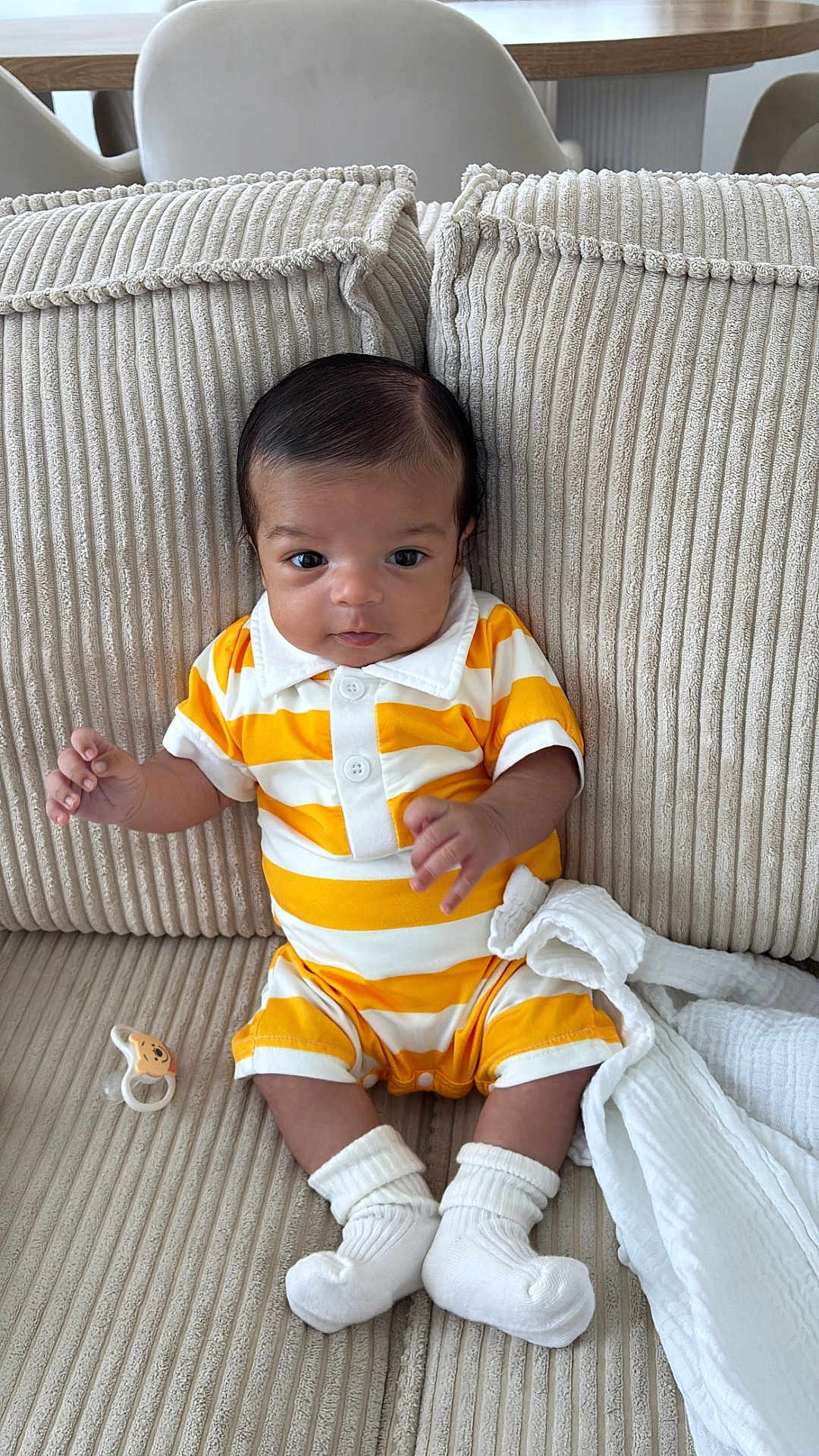 Zahir a rejoint le concours — aidez-le/la à gagner de superbes lots ! baby, infant, child, couch, pillow, striped_clothing, yellow, white, socks, pacifier, indoor, portrait, cute, seated, soft_fabric, furniture, curious, small_hands, head, face