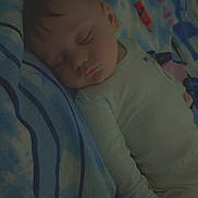 Kaïss participe au concours pour gagner de l'argent avec cette photo : baby, sleeping, blanket, bed, pillow, child, peaceful, curly_hair, infant, cozy, rest, indoors, soft_light, cute, person, portrait, wearing_clothes, lying_down, nap, peace
