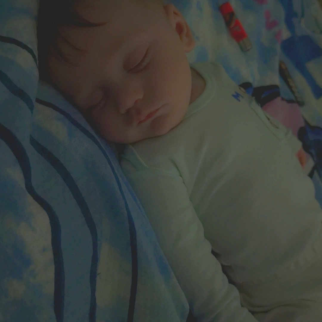 Kaïss participe au concours pour gagner de l'argent avec cette photo : baby, sleeping, blanket, bed, pillow, child, peaceful, curly_hair, infant, cozy, rest, indoors, soft_light, cute, person, portrait, wearing_clothes, lying_down, nap, peace