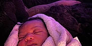 Promise is registered to the contest to win money with this photo: baby, blanket, sleeping, infant, hand, soft_texture, purple_light, indoors, cozy, portrait, wrapped, peaceful, child, comfort, resting, human, face, warm, bedroom, cuddly