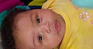 Kaliyah is registered to the contest to win money with this photo: baby, blanket, child, chubby_cheeks, closeup, colorful, cozy, curious, cute, eyeshiny, face, indoors, infant, lying_down, portrait, sleepwear, soft_texture, warm_colors, yellow_clothing, young_child