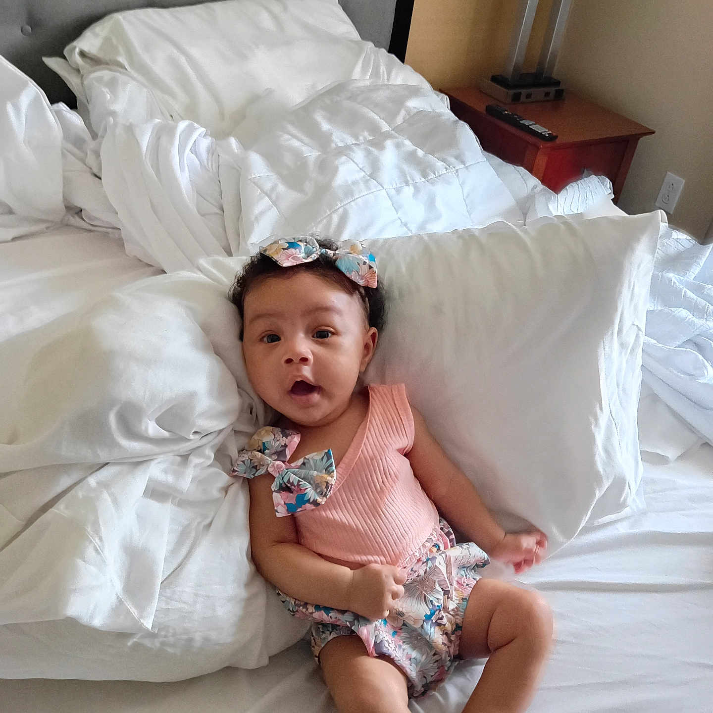 Kaliyah is registered to the contest to win money with this photo: baby, infant, child, bed, pillow, blanket, headband, clothing, cute, indoors, sleepwear, person, skin, smile, expression, furniture, room, lamp, nightstand, curious