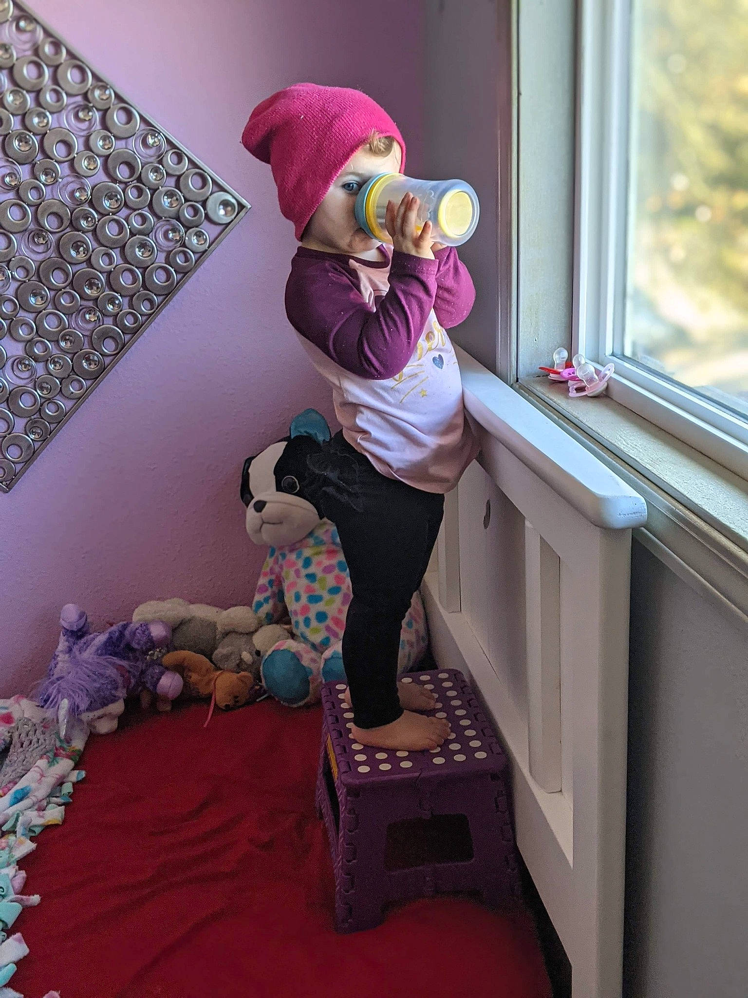 Piper is registered to the contest to win money with this photo: boot, cap, child, comfort, eyewear, floor, flooring, human_leg, knee, leg, magenta, pink, purple, sandal, sock, sunglasses, textile, thigh, toy, wood