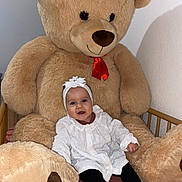 Léonie participe au concours pour gagner de l'argent avec cette photo : baby, black_tights, child, cozy, crib, crib_rail, headband, indoor, infant, nursery, plush, portrait, red_bow, sitting, smile, socks, stuffed_animal, teddy_bear, white_dress, white_headband