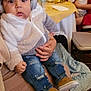 Ethan Pérez is registered to the contest to win money with this photo: baby, child, headphones, jacket, jeans, shoes, adult, table, glasses, people, indoor, party, napkin, bottle, blanket, chair, crowd, event, holding, family