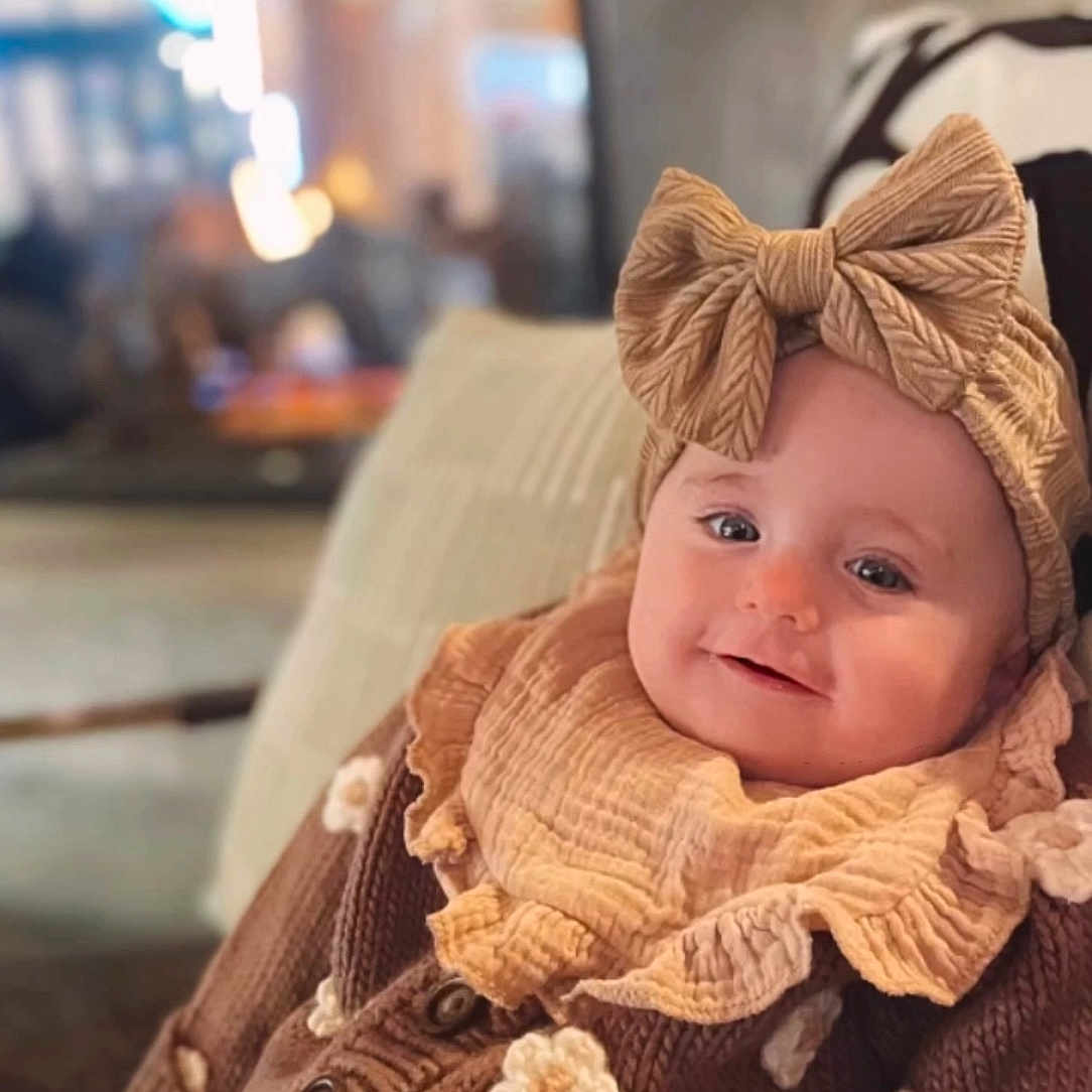 Lisben is registered to the contest to win money with this photo: baby, babylaughing, blanket, blonde, bonnet, cap, clothing, face, hair, happy, hat, head, knitwear, person, photography, portrait, sitting, sleeve, smile, sweater