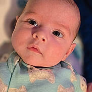 Charlie joined the competition — help win amazing prizes! baby, infant, face, close_up, blue_clothing, onesie, animal_pattern, cute, soft_skin, eyes, portrait, child, young, indoor, newborn, expression, person, adorable, head, baby_garment