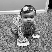 Brinley is registered to the contest to win money with this photo: baby, child, crawling, carpet, headband, flower, dress, lace, floor, indoors, person, portrait, cute, young, infant, curious, looking, monochrome, black_and_white, wall