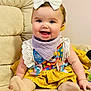 Brinley is registered to the contest to win money with this photo: baby, smile, bow, dress, yellow_skirt, bib, couch, sitting, happy, child, indoor, cute, colorful, pastel_bows, headband, infant, portrait, soft_lighting, cozy, fabric