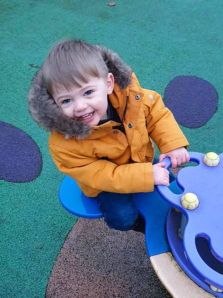 Jensen is registered to the contest to win money with this photo: child, fun, joy, leisure, outdoor_play_equipment, person, play, playground, public_space, recreation, sitting, smile, toddler
