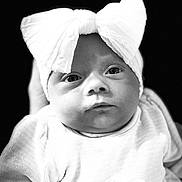 Raven Storm is registered to the contest to win money with this photo: adorable, baby, black_and_white, bow, child, close_up, clothing, cute, expression, eyes, face, headband, infant, monochrome, newborn, person, portrait, soft_texture, studio, young