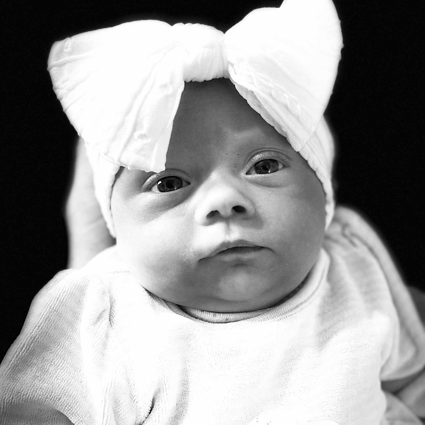 Raven Storm is registered to the contest to win money with this photo: adorable, baby, black_and_white, bow, child, close_up, clothing, cute, expression, eyes, face, headband, infant, monochrome, newborn, person, portrait, soft_texture, studio, young