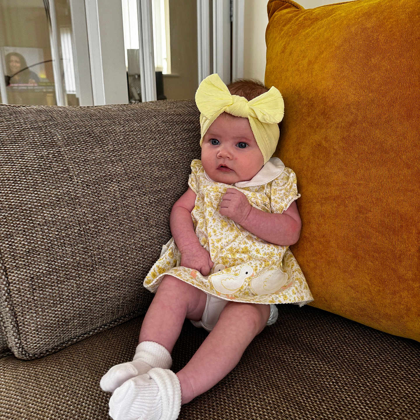 Averie-Bay joined the competition — help win amazing prizes! baby, child, couch, curious, cushion, door, dress, furniture, headband, home, indoors, infant, lamp, living_room, portrait, seated, socks, soft_lighting, window, yellow_bow