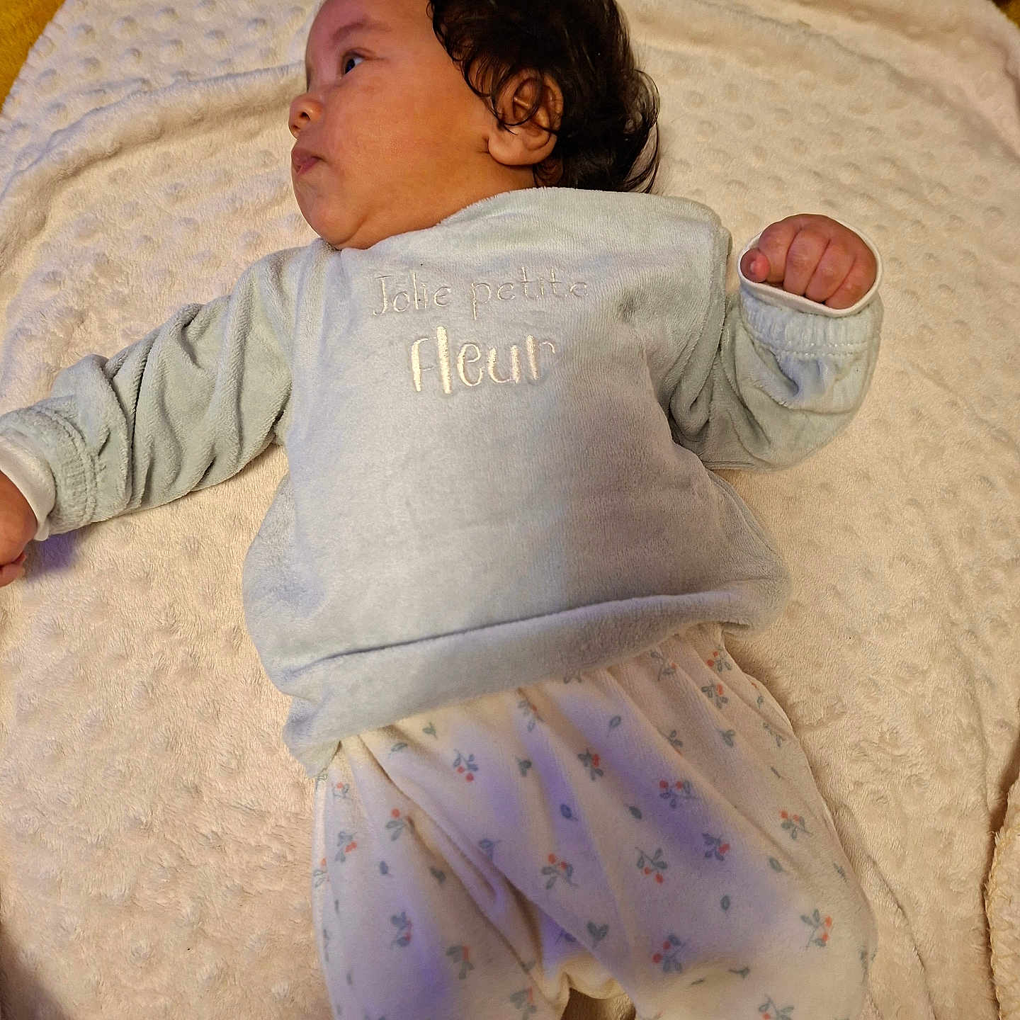 Annaelle participe au concours pour gagner de l'argent avec cette photo : baby, infant, child, blanket, soft_texture, clothing, long_sleeves, pants, floral_pattern, lying_down, curly_hair, indoors, cozy, cute, portrait, person, sleepwear, warm, comfortable, young