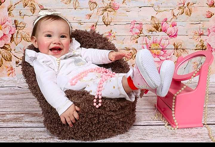 Zoé participe au concours pour gagner de l'argent avec cette photo : baby, baby_toddler_clothing, child, clothing, face, flower, grass, happy, mammal, pattern, people_in_nature, person, petal, photograph, pink, plant, red, sitting, sleeve, smile