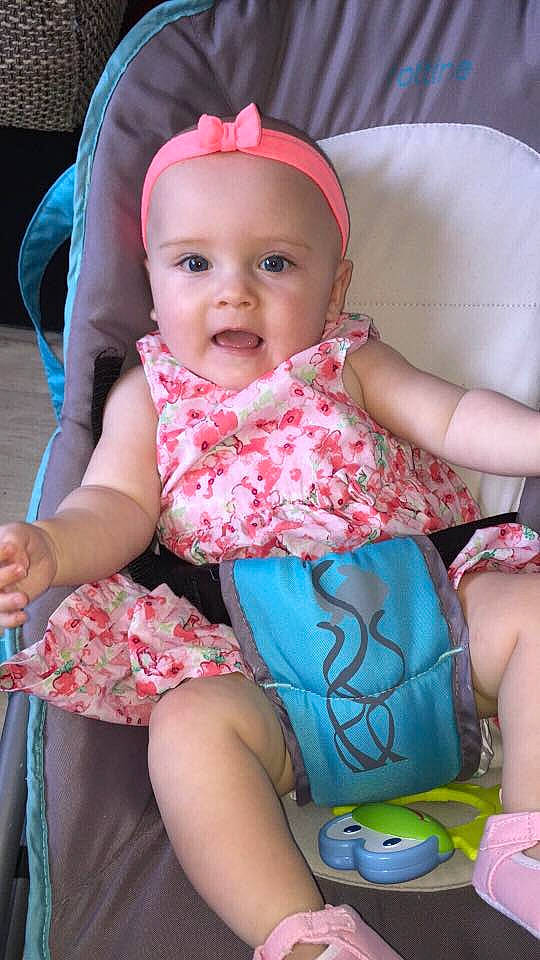 Manon participe au concours pour gagner de l'argent avec cette photo : abdomen, baby_products, child, day, girl, hair_accessory, headgear, human_hair_color, infant, iris, person, pink, product, sitting, skin, smile, textile, toddler