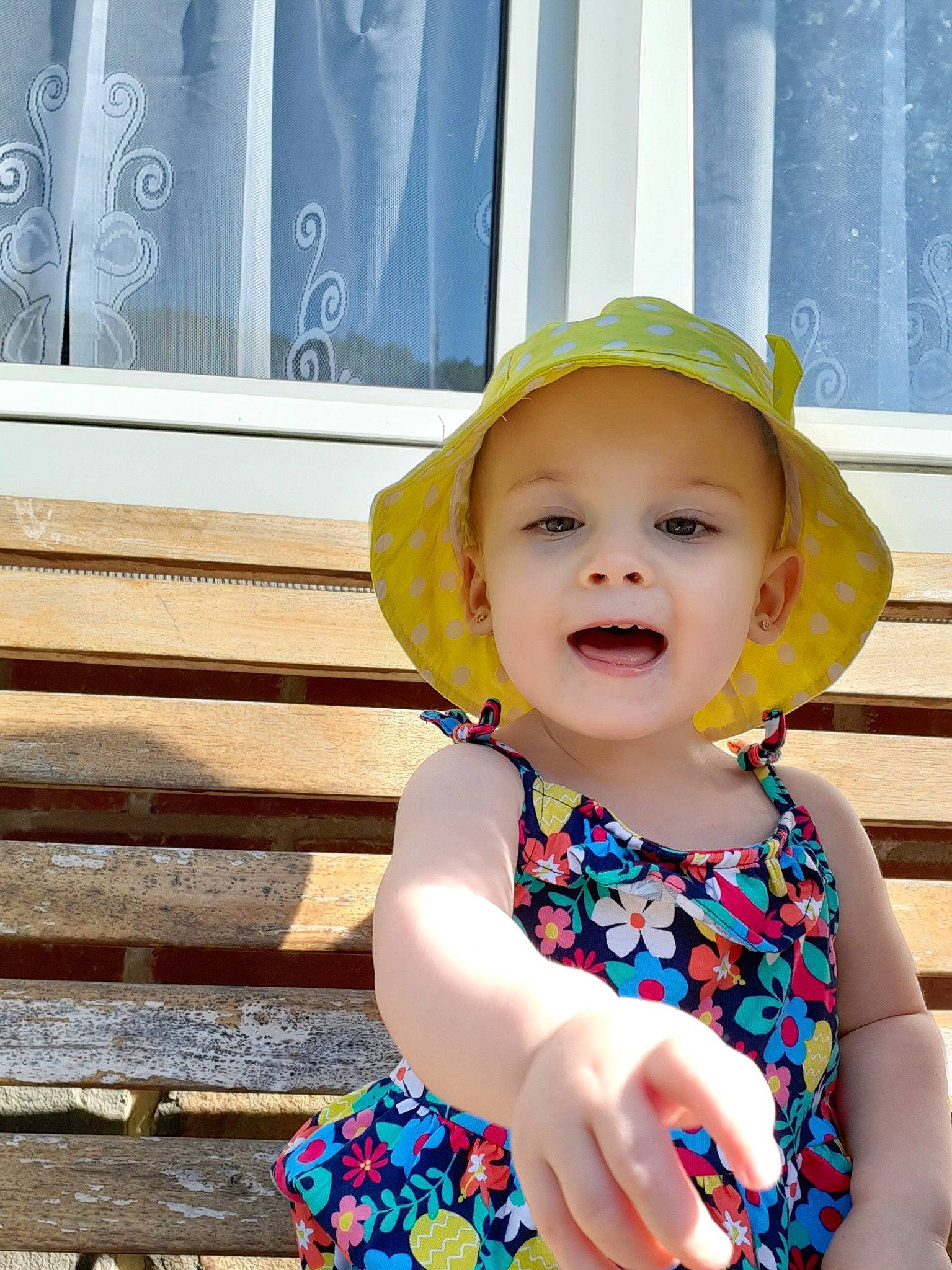 Manon participe au concours pour gagner de l'argent avec cette photo : baby, baby_toddler_clothing, child, child_model, dress, fashion_accessory, happy, hat, headgear, pattern, person, play, skin, smile, summer, sun_hat, toddler, vacation, yellow