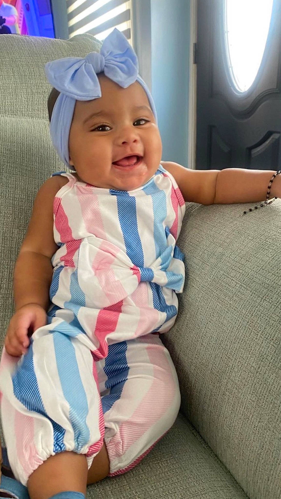 Sophia is registered to the contest to win money with this photo: azure, baby, baby_toddler_clothing, cap, cheek, child, comfort, dress, eye, face, fun, gesture, happy, head, headwear, human_body, person, skin, sleeve, smile