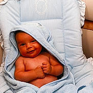 Ravy a rejoint le concours — aidez-le/la à gagner de superbes lots ! baby, smiling, towel, blue_towel, hooded_towel, infant, cushion, striped, seat, upholstery, comfortable, relaxed, skin, baby_skin, baby_face, baby_hands, indoors, portrait, child, cute