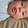 Amina Isla is registered to the contest to win money with this photo: baby, infant, face, eyes, skin, clothing, knitwear, button, laying_down, portrait, close_up, resting, indoor, soft_texture, curious, young_child, head, mouth, nose, person