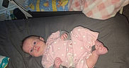 Amina Isla joined the competition — help win amazing prizes! baby, infant, pink_clothing, polka_dots, blanket, bed, lying_down, blue_eyes, indoor, soft_toys, baby_gear, curious, cute, child, newborn, sleeping_area, foot, hand, face, resting
