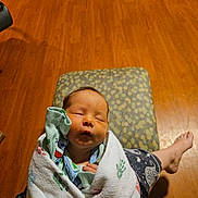 Amina Isla is registered to the contest to win money with this photo: baby, newborn, sleeping, blanket, handprints, infant, wrapped, person, lap, floor, wooden_floor, pajamas, cozy, indoors, relaxing, cute, peaceful, child, human, portrait