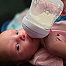 baby, infant, bottle, feeding, milk, pink_clothing, hand, face, eyes, newborn, closeup, skin, child, person, cute, young, indoors, soft_light, portrait, sleepwear