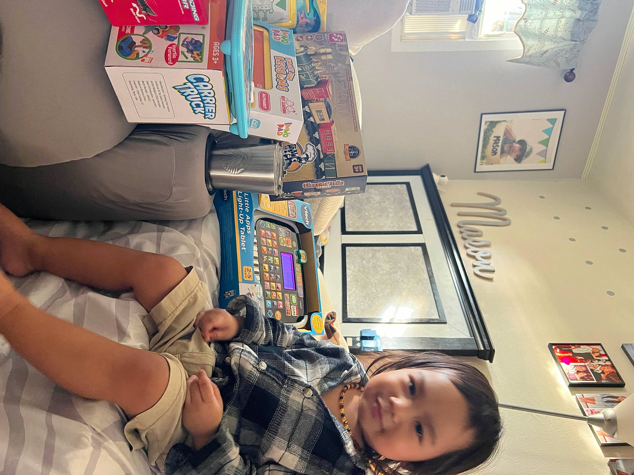 Mason Mikhail is registered to the contest to win money with this photo: ceiling, child, comfort, elbow, fun, house, human_leg, machine, person, photograph, photography, picture_frame, room, shelf, shelving, sitting, smile, snapshot, toddler, visual_arts