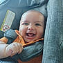 baby, smiling, car_seat, child, orange_shirt, happy, infant, portrait, face, seatbelt, child_safety, cute, indoors, person, skin, hand, young_child, seat, closeup, bright