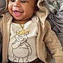baby, child, smiling, hoodie, bear_ears, necklace, gold_chain, winnie_the_pooh, pants, blanket, pattern, bed, happy, cute, face, portrait, video_call, family, indoor, clothing